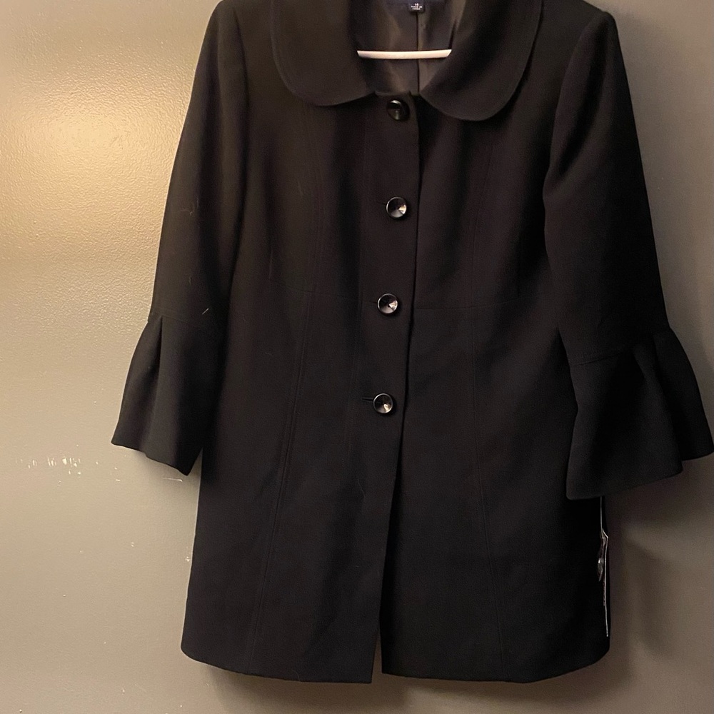 Jones wear black jacket cropped pleated sleeves.